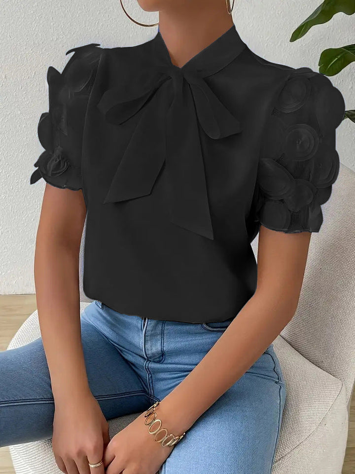 Elegant women’s blouse with a bow and sheer sleeves.